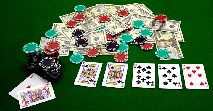 Карточная рука, фишки и банкноты на столе